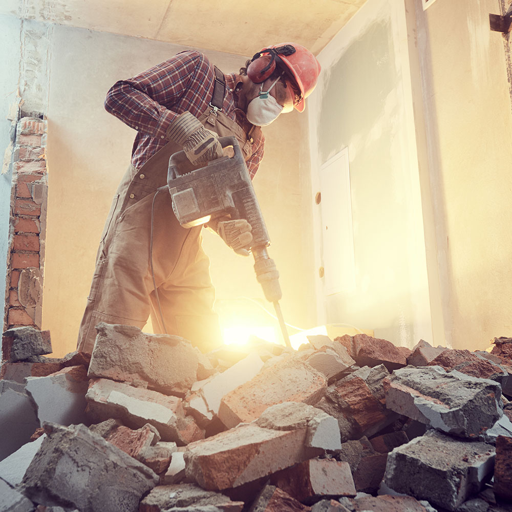 Handwerker bricht Wand ein