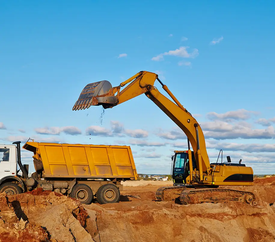 Bagger beim Entladen von Sand in einen Lastwagen