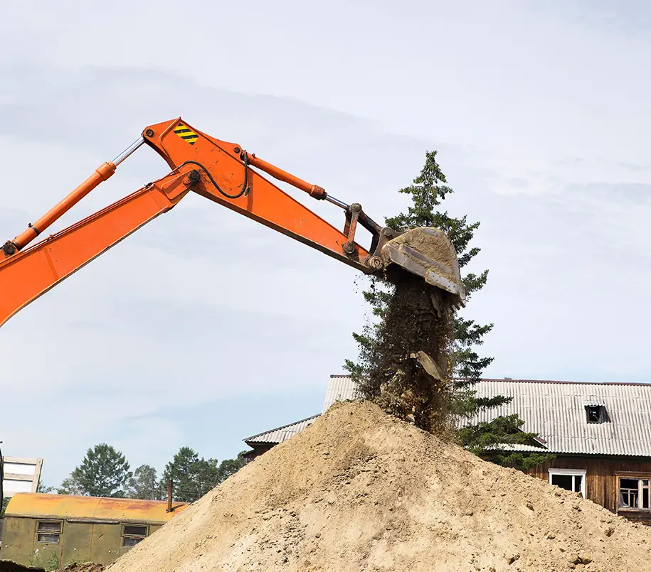 Baggerschaufel über Sandhaufen auf Baustelle