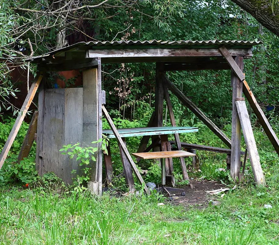 Baufällige Laube mit Sitzgelegenheiten wartet auf den Abriss