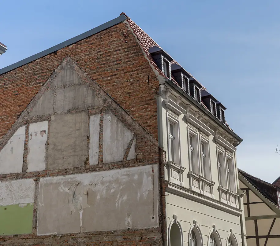 Abgerissenes Haus neben intaktem Altbau in einer Kleinstadt