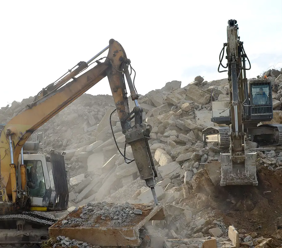 Zwei Bagger beim Abriss eines Gebäudes.Verladen von Schutt: Bagger werden häufig verwendet, um den entstandenen Bauschutt in Container oder Lkws zu laden, damit dieser fachgerecht entsorgt oder wiederverwendet werden kann.