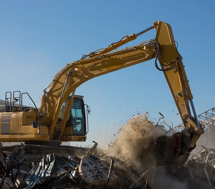 Bagger beim Abriss. Baggerarbeiten beim Abriss bezeichnen den Einsatz von Baggern, um Gebäude oder Strukturen kontrolliert und effizient abzureißen. Bagger spielen eine zentrale Rolle im Abrissprozess und kommen für eine Vielzahl von Aufgaben zum Einsatz, da sie eine große Kraft haben und mit unterschiedlichen Anbaugeräten ausgestattet werden können, um verschiedene Abriss- und Erdarbeiten durchzuführen.