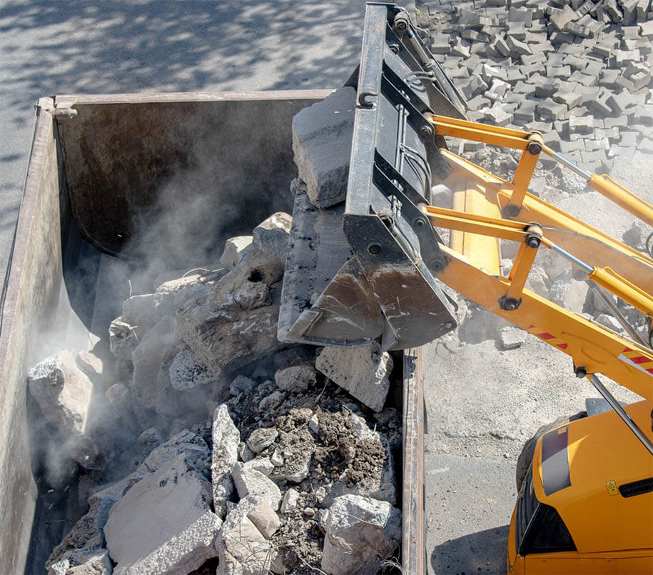 Bulldozer belädt einen Truck mit Bauschutt