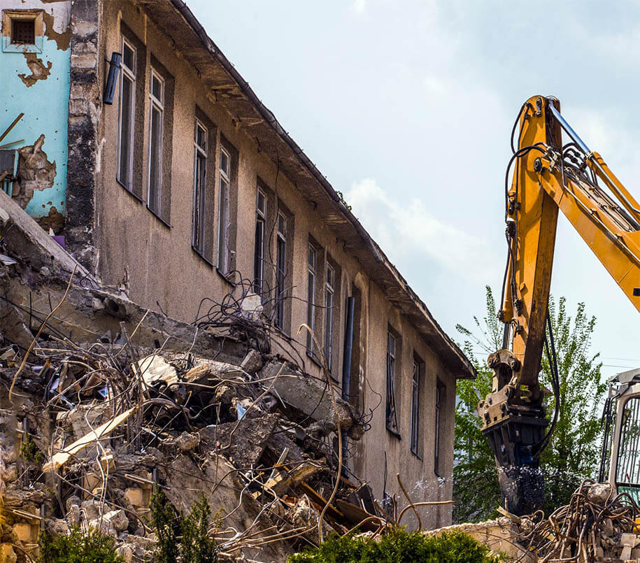 Bagger bei Abriss eines Gebäudeflügels