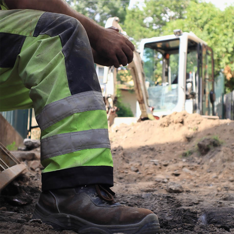 Arbeiter bei einer kurzen Pause vor Bagger