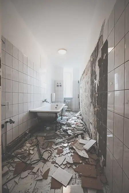 Badezimmer mit teilweise abgeschlagenen Fliesen