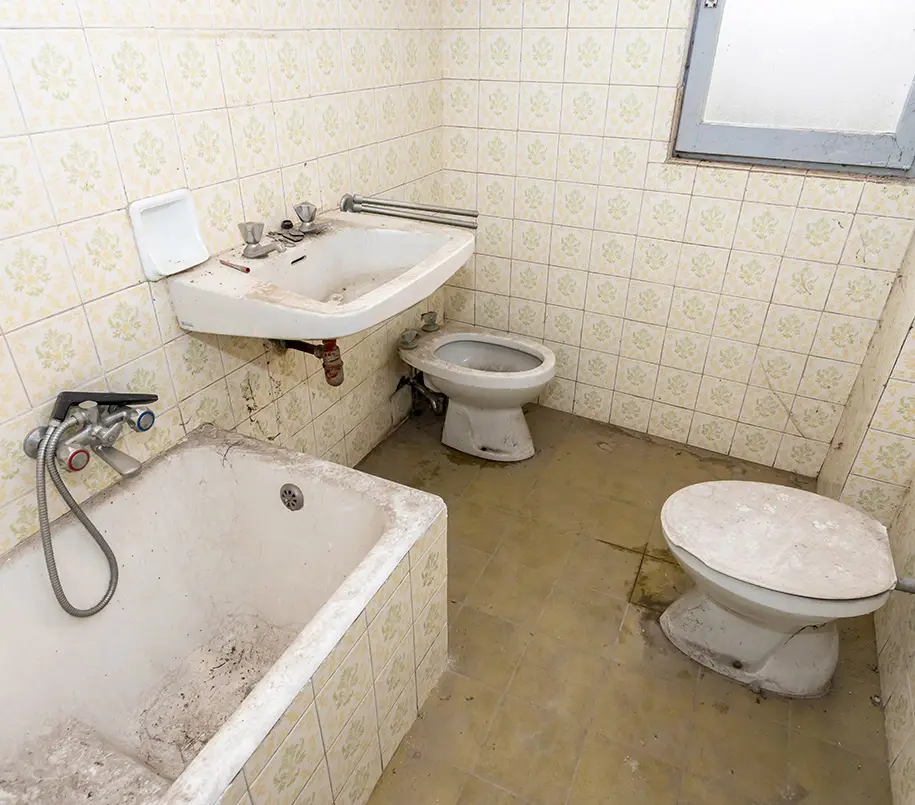 Altes Badezimmer mit abgenutzter Sanitäreinrichtung