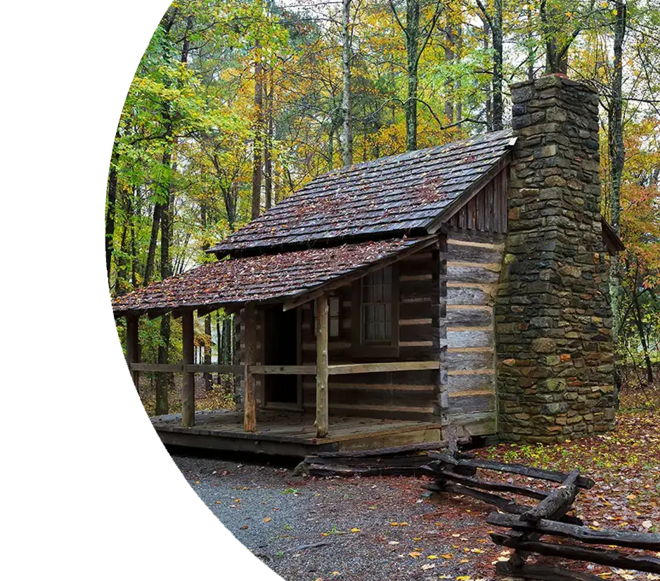 Verrottete Hütte mit steinernem Kamin und Veranda im Wald