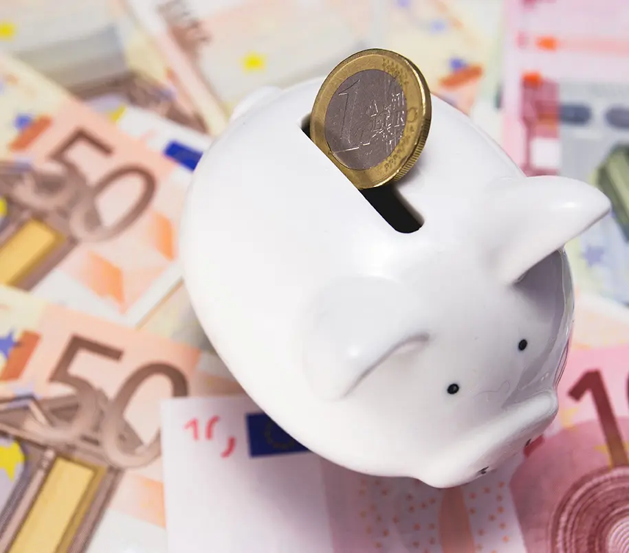 Sparschwein mit Münze steht auf Euroscheinen