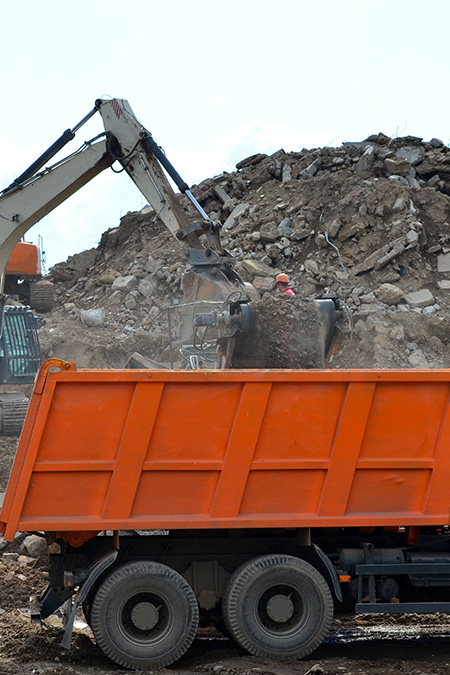 Containerbeladung durch einen Kran mit Bauschutt